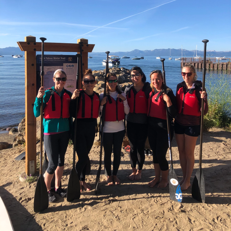 6 women wearing life jackets and holding oars