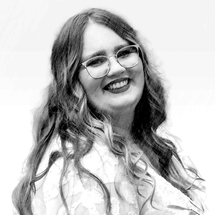 A black and white photo of a smiling woman with glasses.